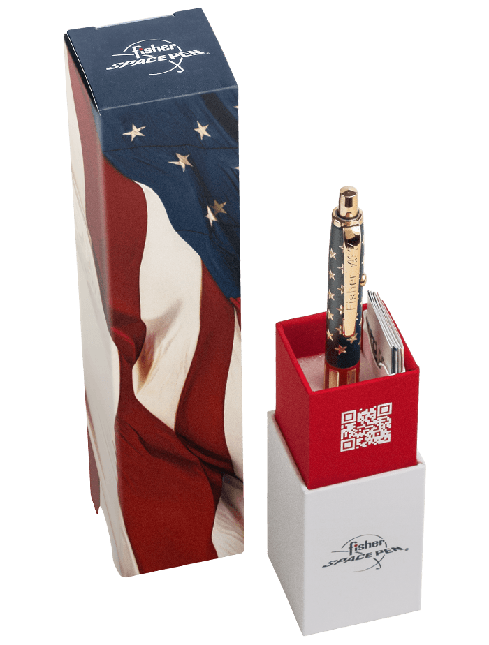 Anerica 250 AG7 Space Pen with American flag (stars and stripes) design, shown upright in an open red presentation box beside its matching sleeve featuring the U.S. flag motif. The pen has gold accents and 'Fisher SPACE PEN' engraving, with a QR code visi
